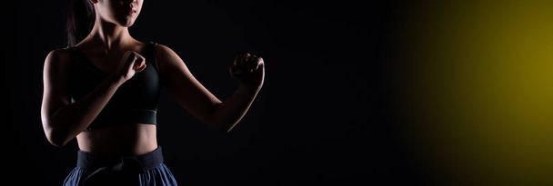 Master Black Belt TaeKwonDo Karate menina que é atleta jovem adolescente mostram poses de luta tradicionais em vestido de esporte, fundo preto isolado, cópia de espaço baixa exposição escura - Foto, Imagem