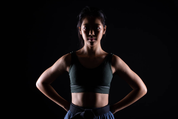 Мастер черный пояс TaeKwonDo девочка-каратистка, которая является спортсменом молодой подросток показать традиционные боевые позы в спортивном платье, черный фон изолированы, скопировать пространство низкого темного воздействия - Фото, изображение