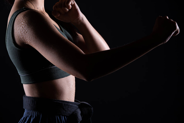 Master Black Belt TaeKwonDo Karate κορίτσι που είναι αθλητής νεαρός έφηβος δείχνουν παραδοσιακά Καταπολέμηση θέτει σε αθλητικό φόρεμα, μαύρο φόντο απομονωμένο, αντιγραφή χώρο χαμηλή σκοτεινή έκθεση - Φωτογραφία, εικόνα