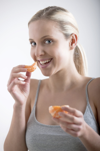 Beautiful woman eating orange - Photo, Image