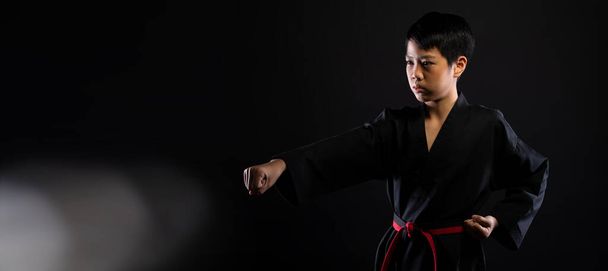Master Red Black Belt TaeKwonDo Karate boy who is athlete young teenager show traditional Fighting poses in sport dress, black background isolated copy space - Fotó, kép