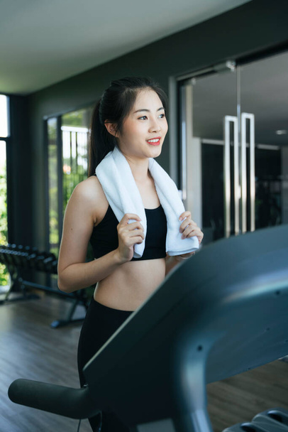 Healthy asian woman running on treadmill machine in gym. - Fotografie, Obrázek
