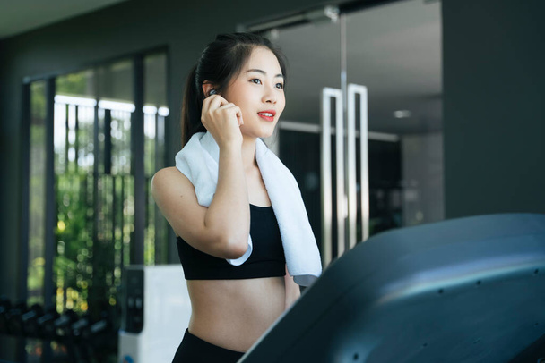 Saludable asiático mujer corriendo en cinta de correr máquina en gimnasio. - Foto, Imagen