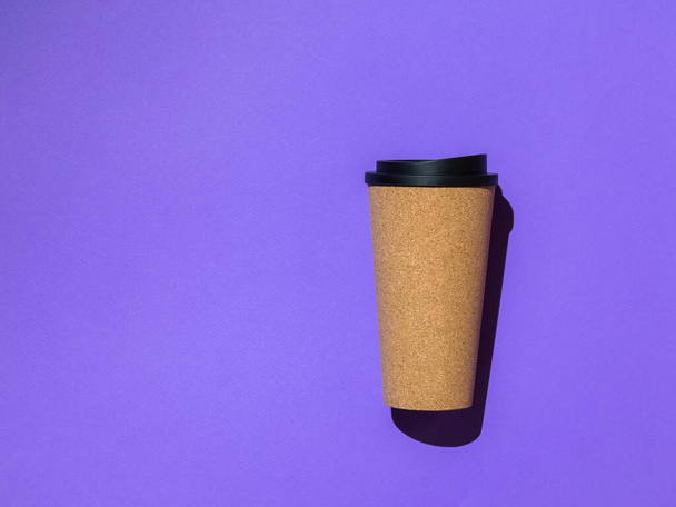 tasse de café avec un couvercle noir sur un fond violet. - Photo, image
