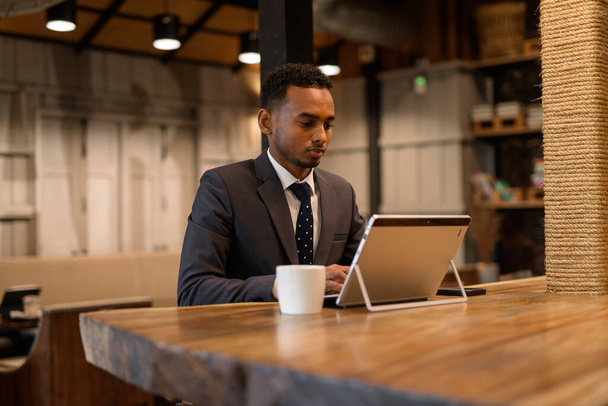 Fiatal afrikai üzletember laptopot használ a kávézóban - Fotó, kép