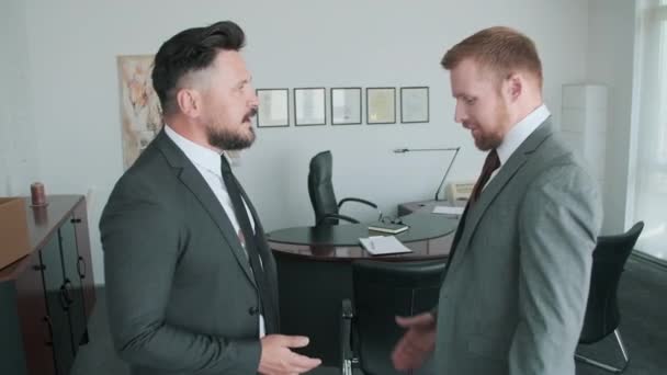 Πλάγια εικόνα δύο όμορφων υπαλλήλων γραφείου με επίσημο ένδυμα να μιλάνε και να σφίγγουν τα χέρια μετά την επίτευξη συμφωνίας - Πλάνα, βίντεο