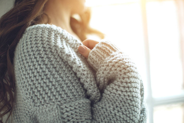 Young beautiful woman in warm knitted clothes at home. Female indoor portrait. - Foto, Bild