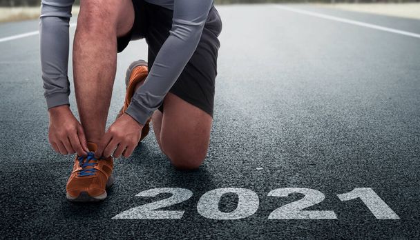 Runner man prepares to run on the 2021 line. Happy New Year 2021 - Photo, Image