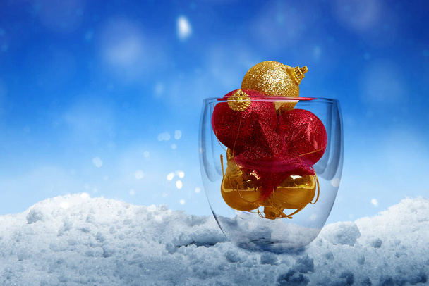 Colorful Christmas ornament in the glass bowl on the snow with snowfall background. Merry Christmas - Foto, afbeelding