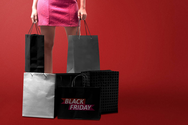 Women carrying a shopping bag with a colored background. Black Friday concept - Fotoğraf, Görsel