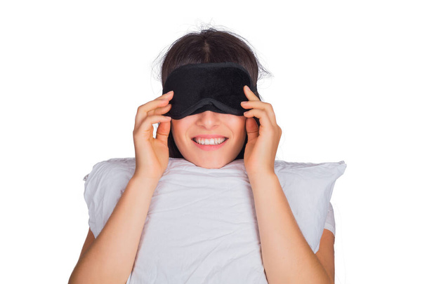 woman wearing sleep mask and holding a pillow. - 写真・画像