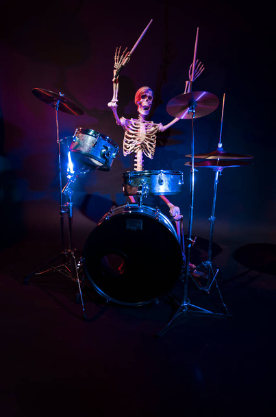 Esqueleto contra um fundo escuro balançando para fora em luzes azuis - Foto, Imagem