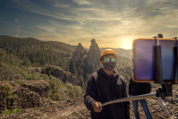 Detailní záběr latinskoamerického horolezce na hoře, jak si bere selfie v masce - Fotografie, Obrázek
