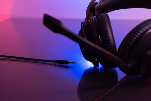 Ακουστικά Gamer Σκούρο φόντο και πολύχρωμο φως. - Φωτογραφία, εικόνα
