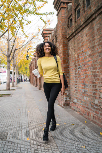 Afro-american woman walking on the street. - 写真・画像
