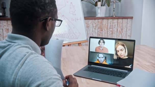 Een online wiskundeles - een Afrikaans-Amerikaanse mannelerares die aantekeningen maakt en aan zijn leerlingen op het scherm laat zien - Video