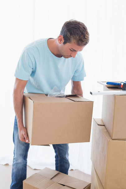 Man with cardboard boxes in new house - Photo, Image