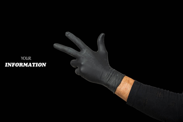 Hand Toont Drie Vingers. Man 's hand in zwarte rubberen handschoen doet gebaar nummer drie, gebarentaal geïsoleerd op zwarte achtergrond. Een studio opname. Hoge kwaliteit foto met ruimte voor tekst, logo.  - Foto, afbeelding