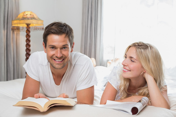 Relaxed casual couple reading books in bed - Фото, изображение