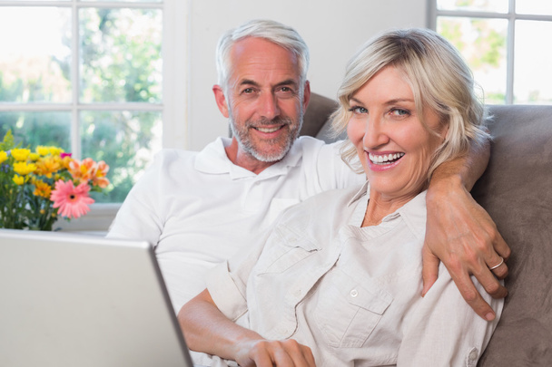 Relaxed mature couple with laptop at home - Photo, image