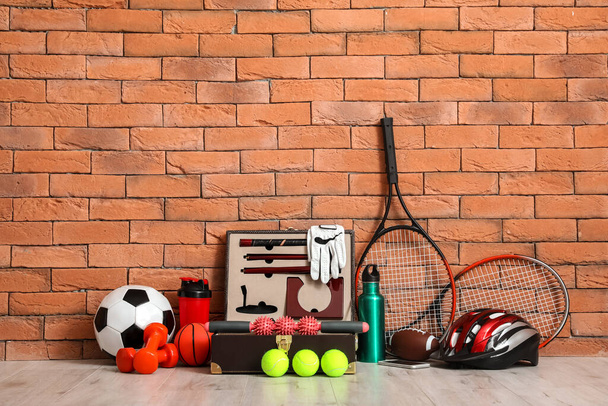 Conjunto de equipamentos esportivos no chão perto da parede de tijolo - Foto, Imagem