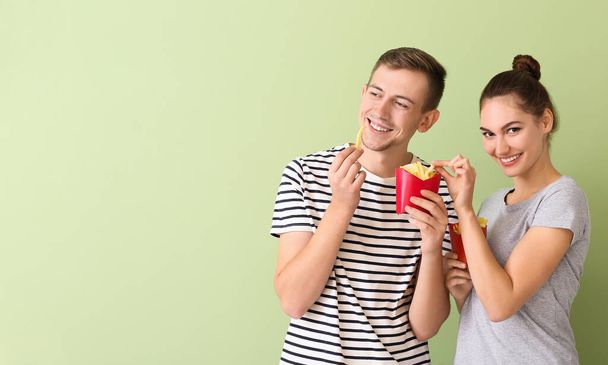 Nuori pari ranskalaisia perunoita värillinen tausta - Valokuva, kuva