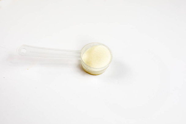 cologen σκόνη για την αναζωογόνηση του προσώπου σε κουτάλι σερβιρίσματος σε λευκό φόντο - Φωτογραφία, εικόνα