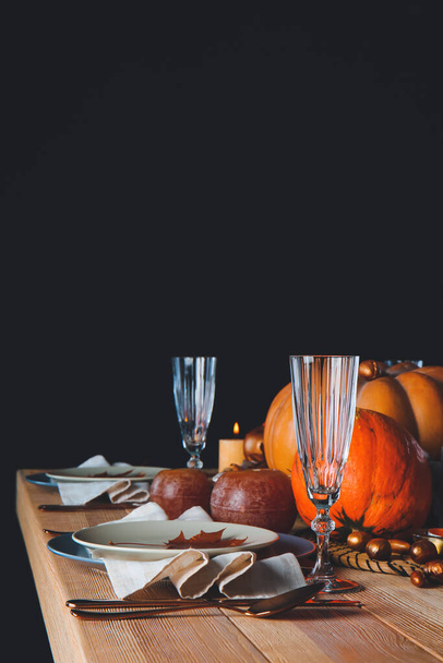 Beautiful table setting with pumpkins on dark background - 写真・画像