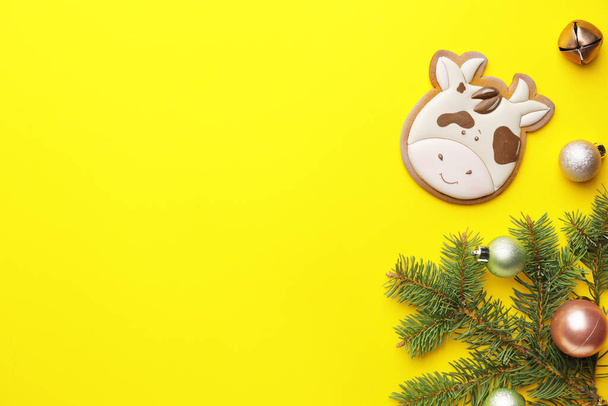 Leckere Plätzchen in Form von Stier und Weihnachtsdekor auf farbigem Hintergrund - Foto, Bild