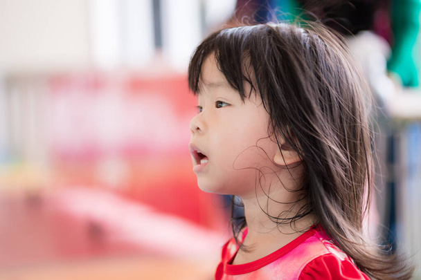 Side view of a cute Asian girl was shocked with a mouth open expression. Head shot child was shocked by something in front of her. Kid is 3 years old. - Foto, imagen