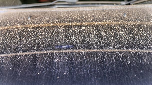 Vlekken vuil stof dat de regen raakte en plakken op de motorkap. Schoonmaken. - Foto, afbeelding