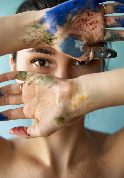 crazy portrait of young girl painter. photo of woman with paint brush strokes on the skin - Photo, image