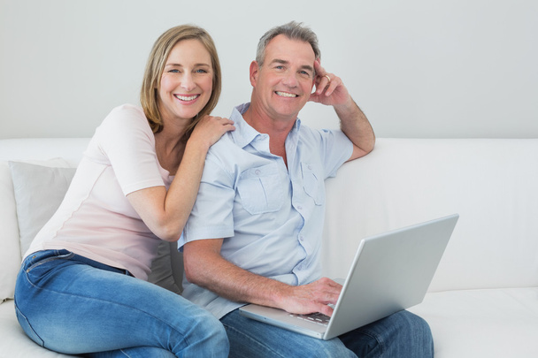 Portrait of a relaxed couple using laptop at home - Fotografie, Obrázek
