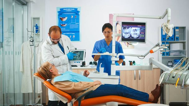 Hammaslääkäri näkyy tabletin hampaat röntgenkuva - Valokuva, kuva