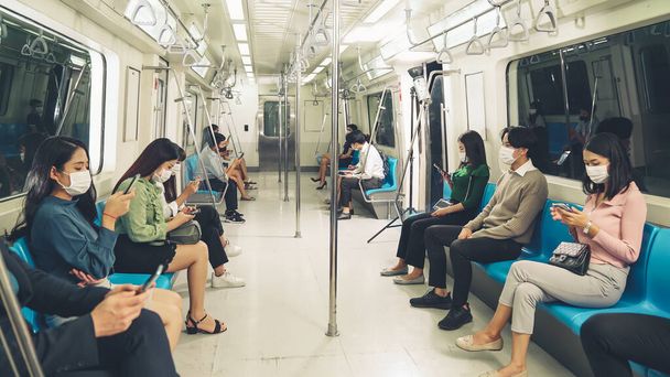 Multitud de personas que usan mascarilla facial en un concurrido tren público de metro - Foto, imagen