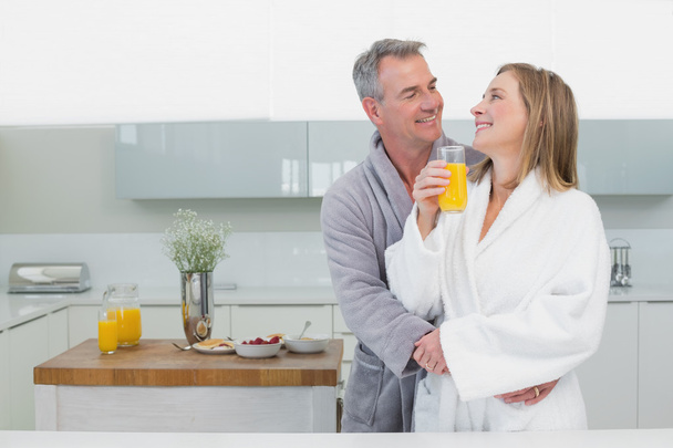 Man embracing woman from behind in kitchen - Photo, image