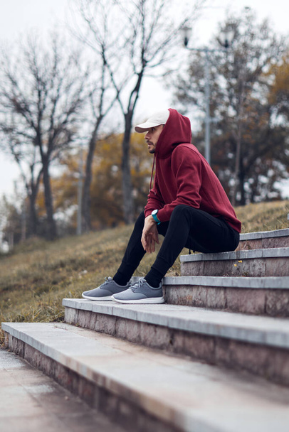 Athletic sporty man training in hoodie sweatshirt in urban city park. - Foto, immagini