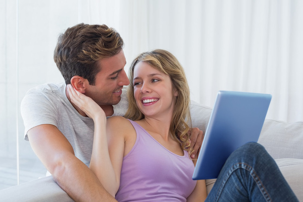Happy young couple using digital tablet together - Foto, imagen