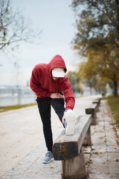 Athletic sporty man training in hoodie sweatshirt in urban city park. - Foto, immagini