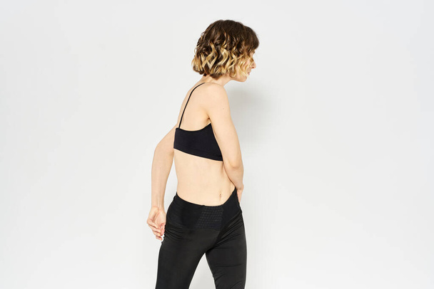 Femme mince en leggings sur un fond clair faisant des exercices de gymnastique de remise en forme - Photo, image