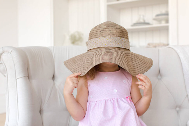 Linda chica escondiendo la cara detrás de sombrero de paja - Foto, Imagen