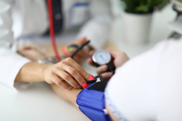 Doctors female hand measures blood pressure to patient. - Foto, immagini