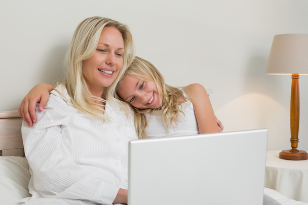 Relaxed mother and daughter surfing on laptop - Foto, imagen