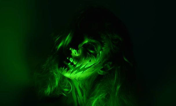 Frau geschminkt und im Dunkeln mit farbigen LED-Lichtern fotografiert. - Foto, Bild