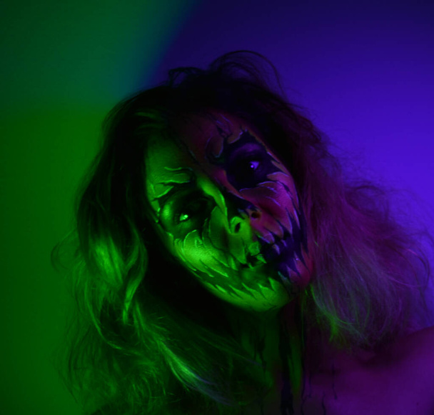 Kobieta z makijażem i fotografowane w ciemności z kolorowymi diodami LED. - Zdjęcie, obraz