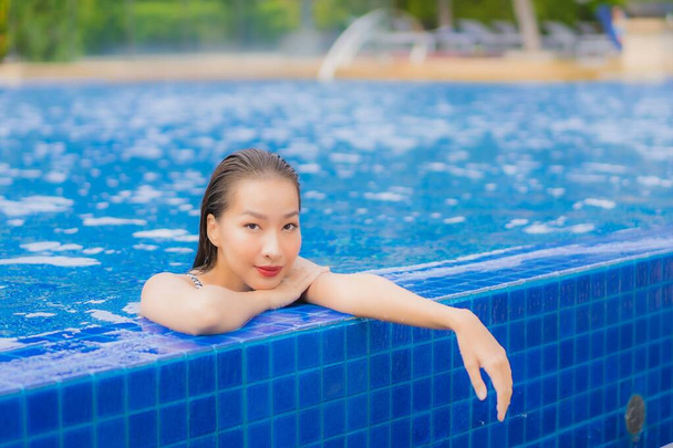 Portrét krásná mladá asijská žena relax úsměv volný čas kolem venkovního bazénu v hotelovém resortu na dovolenou cestování - Fotografie, Obrázek
