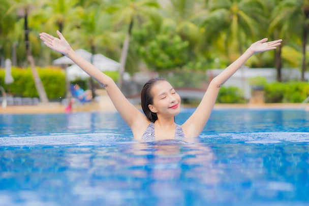 Portrét krásná mladá asijská žena relax úsměv volný čas kolem venkovního bazénu v hotelovém resortu na dovolenou cestování - Fotografie, Obrázek