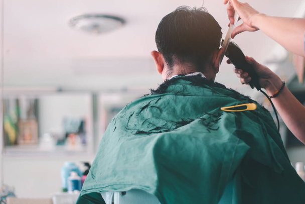 Rücken eines Mannes, der im Friseursalon Haare schneidet - Foto, Bild