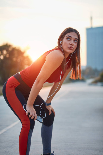 Modern young woman making pause during jogging / exercise. - Foto, immagini