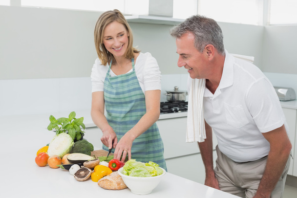 Happy couple preparing food together in kitchen - Фото, зображення